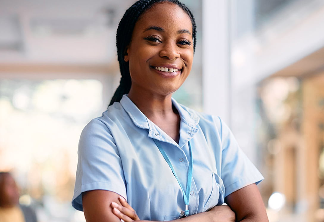 healthcare worker smiling while standing in a medical office 